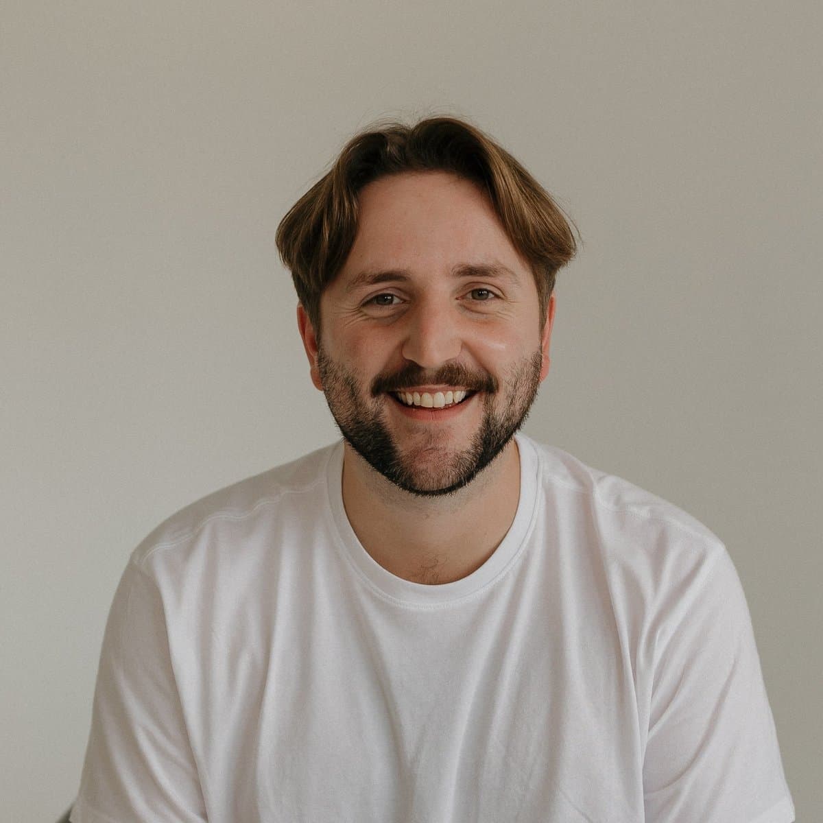 Miles, smiling in a white t-shirt, the worship pastor and builder behind Steadfast